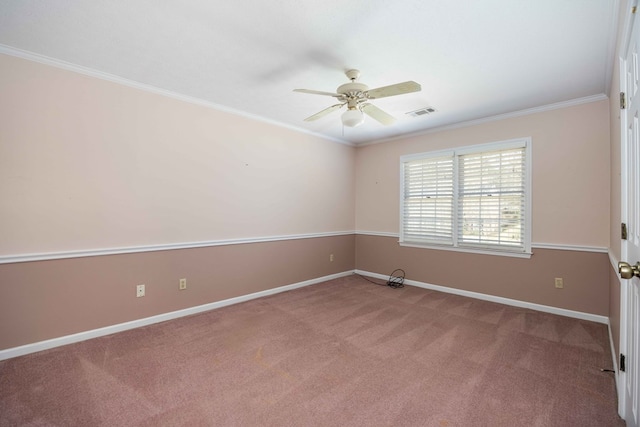 carpeted empty room with baseboards, ceiling fan, visible vents, and crown molding