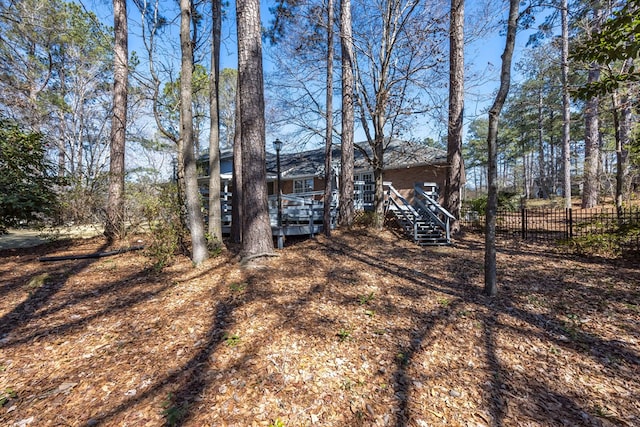 view of yard featuring stairway, fence, and a wooden deck