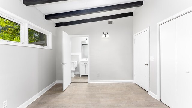 hallway with lofted ceiling with beams and light hardwood / wood-style floors