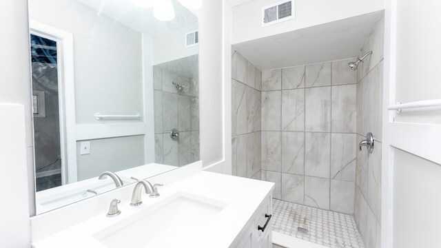 bathroom with vanity and tiled shower