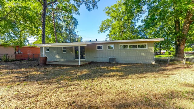 rear view of house with a yard, a patio, and cooling unit