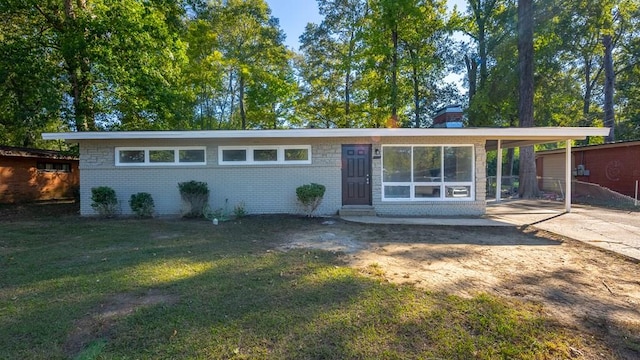 single story home featuring a front lawn and a carport