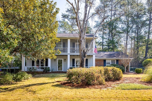 view of front facade with a front yard, a porch, and brick siding