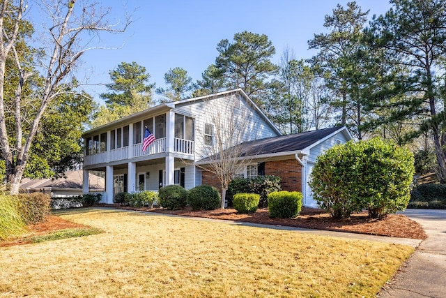 view of front of property featuring brick siding, driveway, and a sunroom