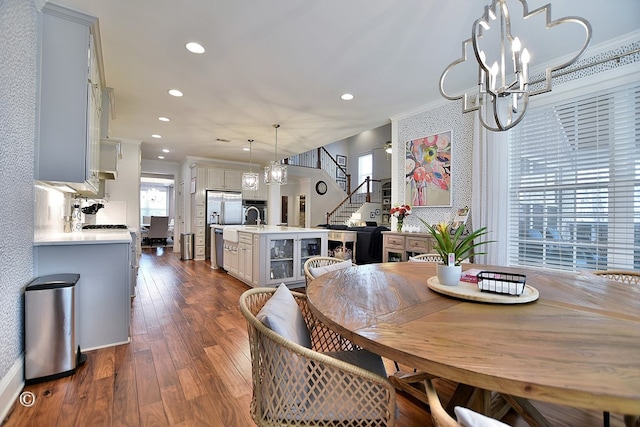 dining area featuring ornamental molding, stairway, dark wood finished floors, and a healthy amount of sunlight