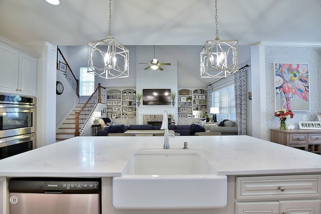 kitchen with white cabinetry, appliances with stainless steel finishes, open floor plan, and a sink