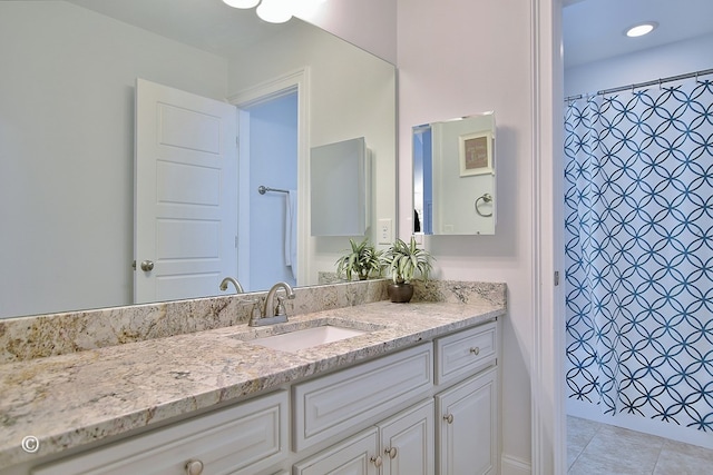 full bath with a shower with shower curtain, tile patterned floors, and vanity