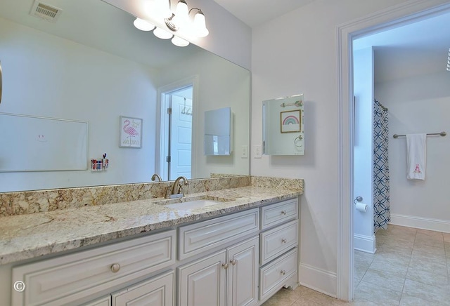 bathroom with tile patterned flooring, vanity, visible vents, and baseboards