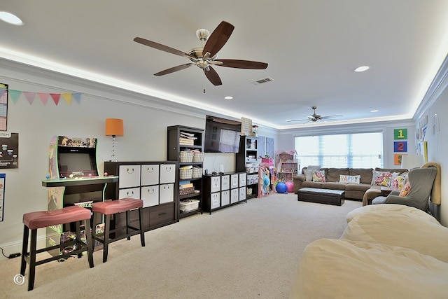 living area with recessed lighting, light colored carpet, visible vents, ornamental molding, and a raised ceiling