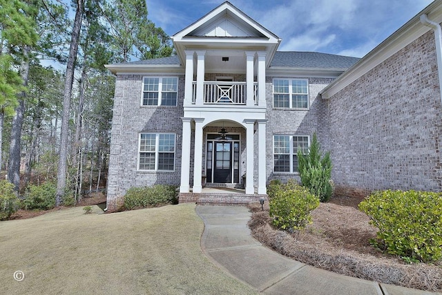 property entrance with a balcony and brick siding