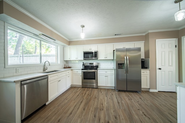 6801 Buckeye Way, Columbus, GA 31904 - kitchen with stainless steel appliances, white cabinetry, dark wood-style flooring, decorative backsplash, and ornamental molding