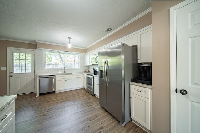 6801 Buckeye Way, Columbus, GA 31904 - kitchen with appliances with stainless steel finishes, wood finished floors, decorative backsplash, white cabinets, and light countertops