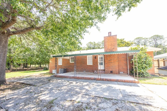 8085 Ga Highway 0219, Hamilton, GA 31811 - back of property featuring a chimney, brick siding, and central AC