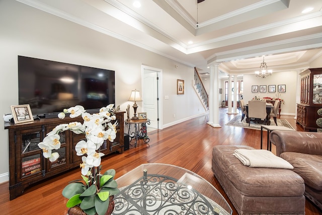 1438 Grove Park Dr Unit 8B, Columbus, GA 31904 - living room featuring decorative columns, a tray ceiling, a chandelier, wood finished floors, and baseboards