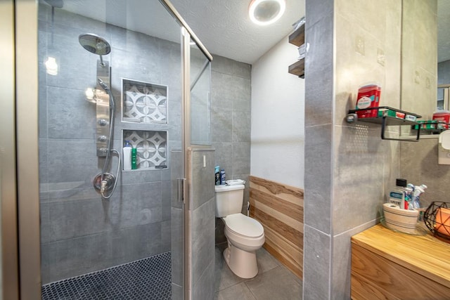 bathroom featuring a shower with shower door, a textured ceiling, and toilet