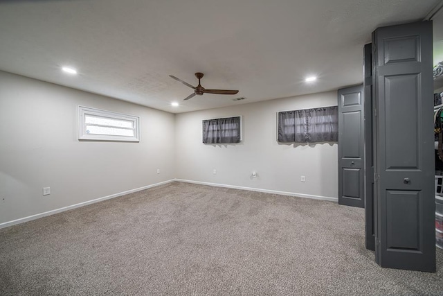 basement with ceiling fan and carpet floors