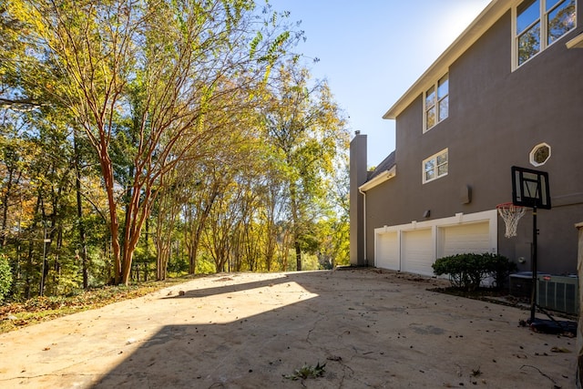 view of yard with central AC unit and a garage