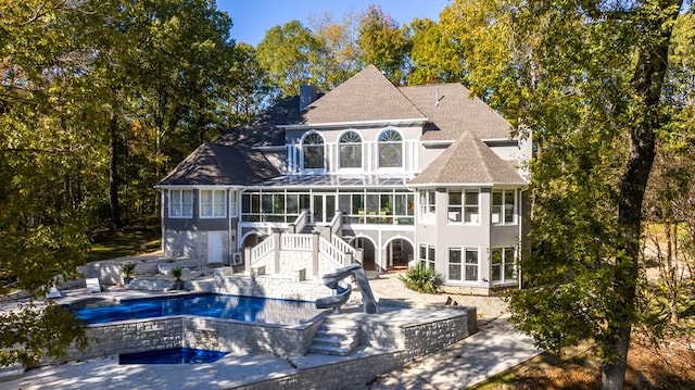 back of property with a sunroom and a patio