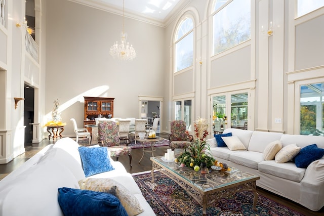 living room featuring dark hardwood / wood-style flooring, ornamental molding, a high ceiling, and an inviting chandelier