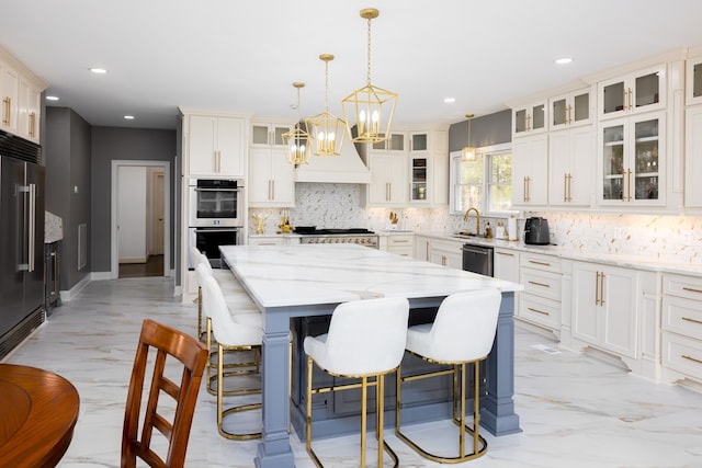 kitchen with light stone countertops, hanging light fixtures, stainless steel appliances, tasteful backsplash, and a kitchen island