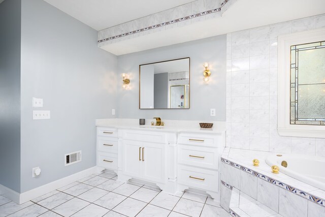 5410 River Oak Way, Phenix City, AL 36867 - bathroom with vanity, a relaxing tiled tub, baseboards, and marble finish floors