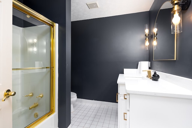 full bathroom featuring vanity, combined bath / shower with glass door, tile patterned flooring, toilet, and a textured ceiling