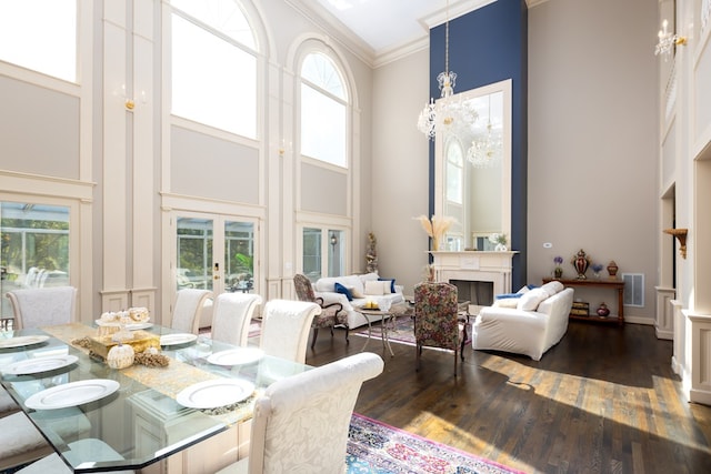 dining area featuring a high ceiling, dark wood-type flooring, and a healthy amount of sunlight