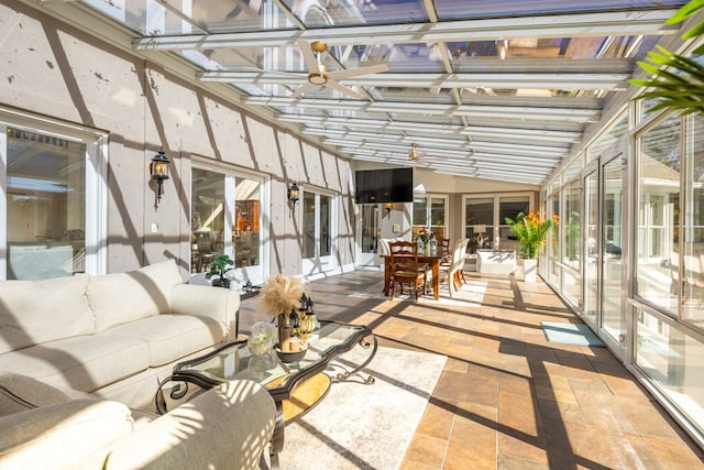 unfurnished sunroom featuring ceiling fan and vaulted ceiling