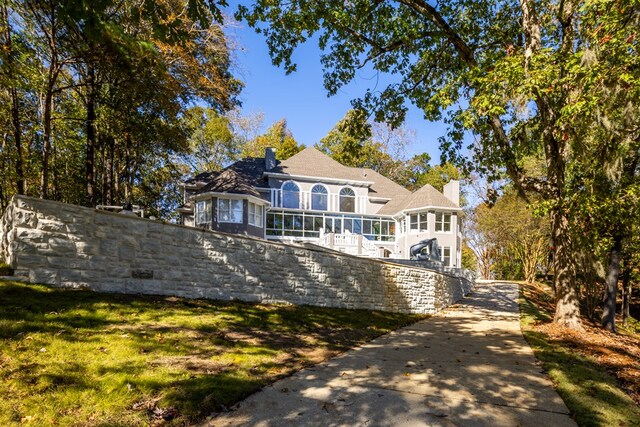 5410 River Oak Way, Phenix City, AL 36867 - view of front facade with a chimney, a sunroom, and concrete driveway