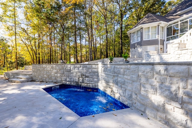 view of pool with a patio area and pool water feature