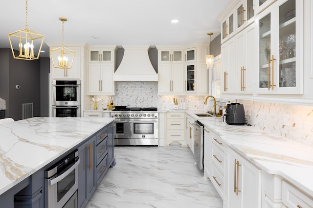 kitchen with pendant lighting, sink, stainless steel appliances, and custom exhaust hood