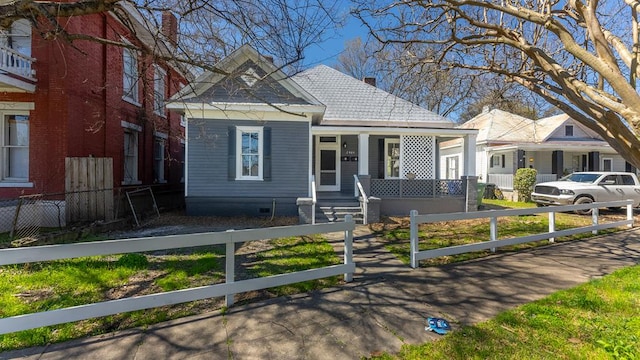 bungalow-style house featuring covered porch and a fenced front yard