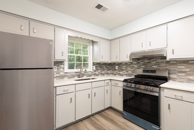5011 Edo Ct, Columbus, GA 31907 - kitchen featuring appliances with stainless steel finishes, under cabinet range hood, light countertops, light wood-style floors, and white cabinetry