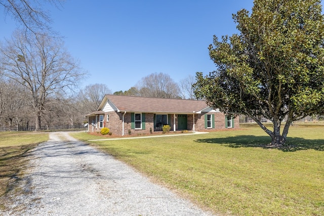 view of front of property with brick siding, driveway, and a front yard