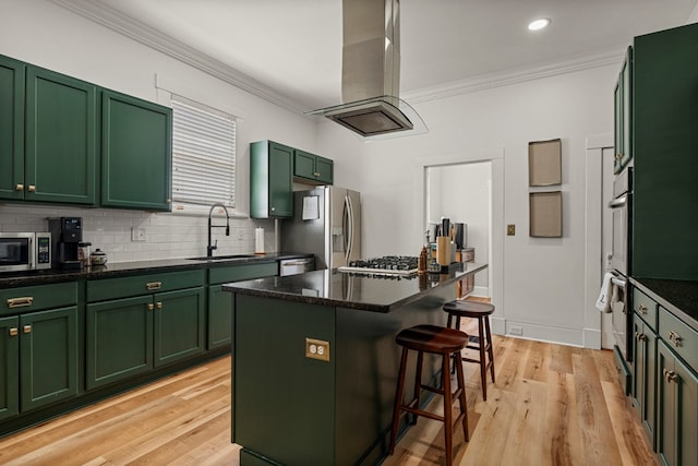 1917 Dimon St, Columbus, GA 31906 - kitchen featuring green cabinets, stainless steel appliances, ornamental molding, a kitchen bar, and light wood finished floors