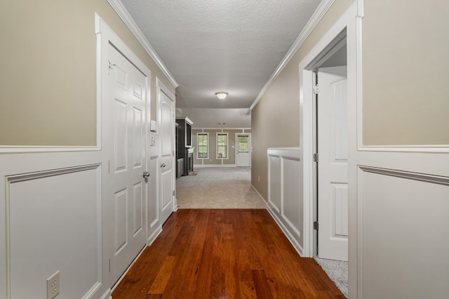 corridor featuring ornamental molding, hardwood / wood-style floors, and a textured ceiling