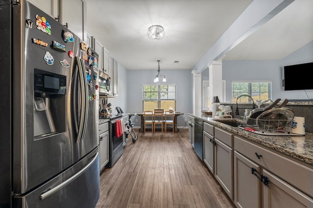 28 Red Maple Dr, Phenix City, AL 36869 - kitchen with wood finished floors, a sink, dark stone counters, stainless steel appliances, and ornate columns