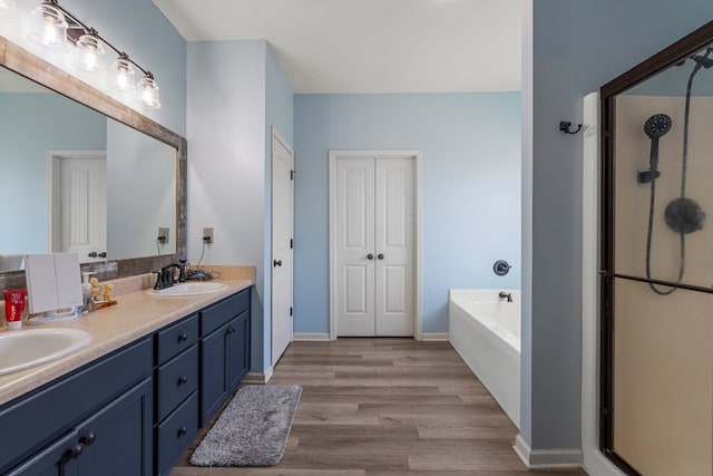 28 Red Maple Dr, Phenix City, AL 36869 - bathroom with double vanity, a bath, a stall shower, wood finished floors, and a sink