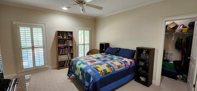 bedroom with crown molding, ceiling fan, carpet, and a closet