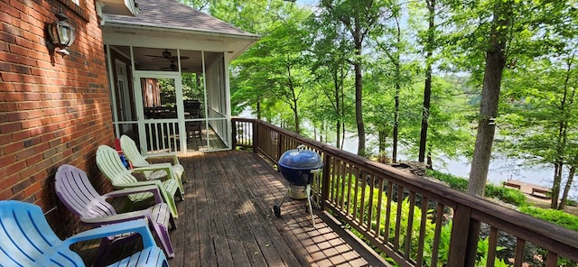 wooden deck featuring a ceiling fan and a sunroom