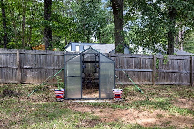 view of greenhouse with a fenced backyard