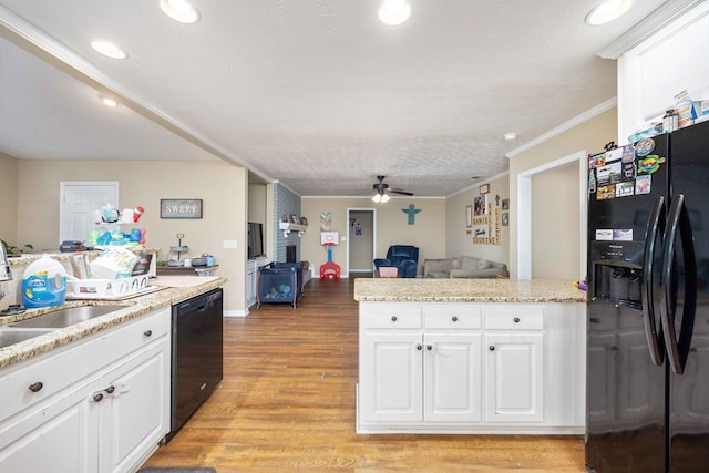 kitchen featuring white cabinets, ceiling fan, open floor plan, and black appliances