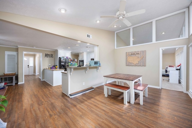 dining area featuring ceiling fan, visible vents, baseboards, dark wood-style floors, and lofted ceiling