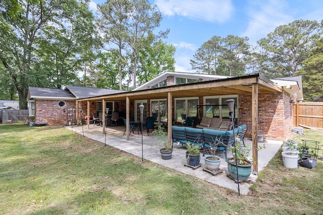rear view of property featuring brick siding, an outdoor hangout area, a fenced backyard, a patio area, and a yard
