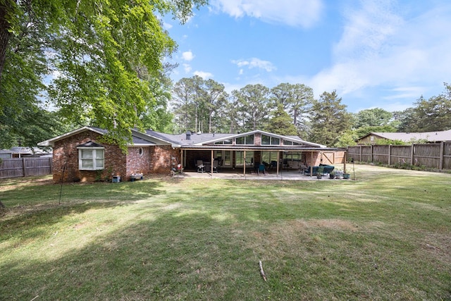 rear view of property with a patio, a fenced backyard, and a yard