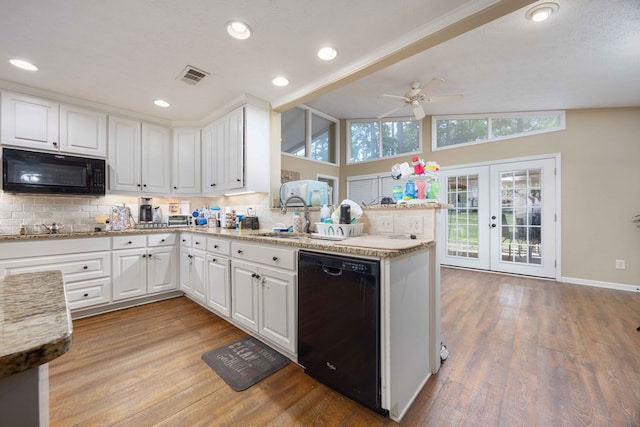 kitchen with a sink, a peninsula, tasteful backsplash, visible vents, and black appliances
