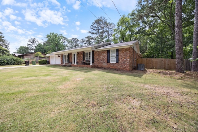 ranch-style house featuring fence, an attached garage, and a front lawn