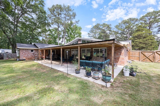 back of property with a fenced backyard, a lawn, a patio area, and brick siding