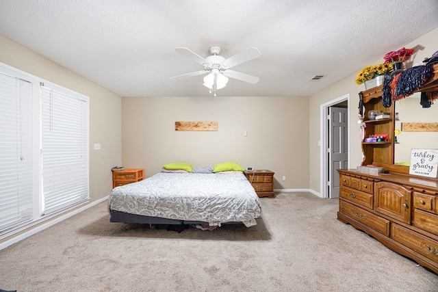 bedroom featuring baseboards, ceiling fan, light carpet, and visible vents