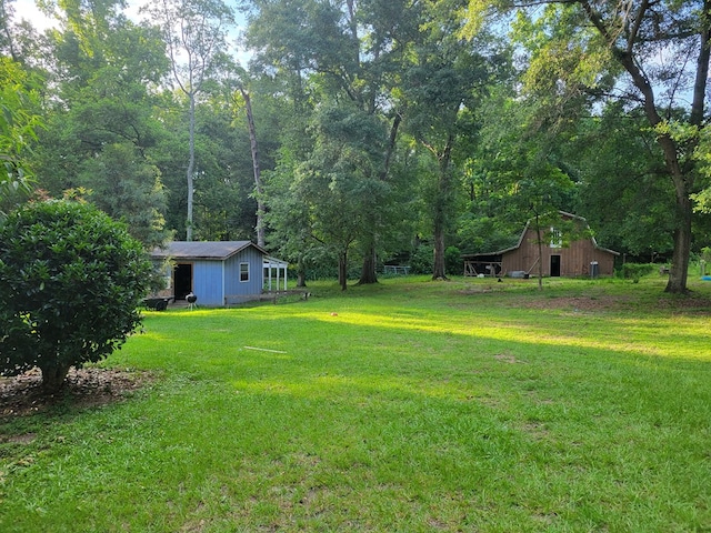 7505 Beaver Run Rd, Midland, GA 31820 - view of green lawn with an outbuilding, a wooded view, and a barn